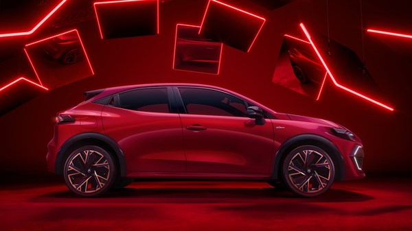 Ново Renault Clio во црвена боја, страничен поглед со изразени линии на кровот и заден спојлер.