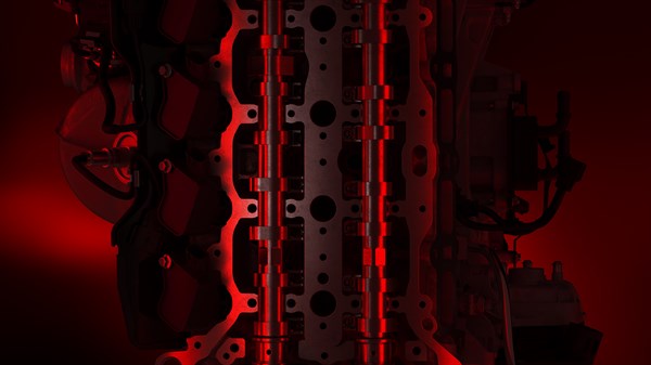 Поглед на хибридниот моторен блок на новото возило Renault Clio со акцентирани метални елементи во црвена средина.